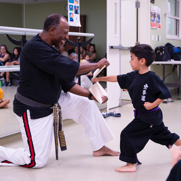 image of a karate student in the Little Dragons Program breaking a board with a punch at Grandmaster Quinton Egson's Dojo